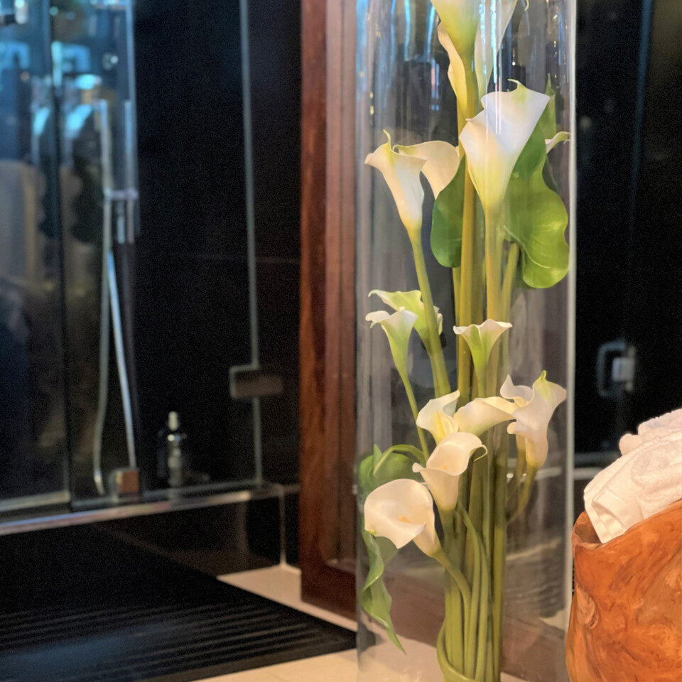 Weiß Calla Lilies und Blätter im Rota Cylinder